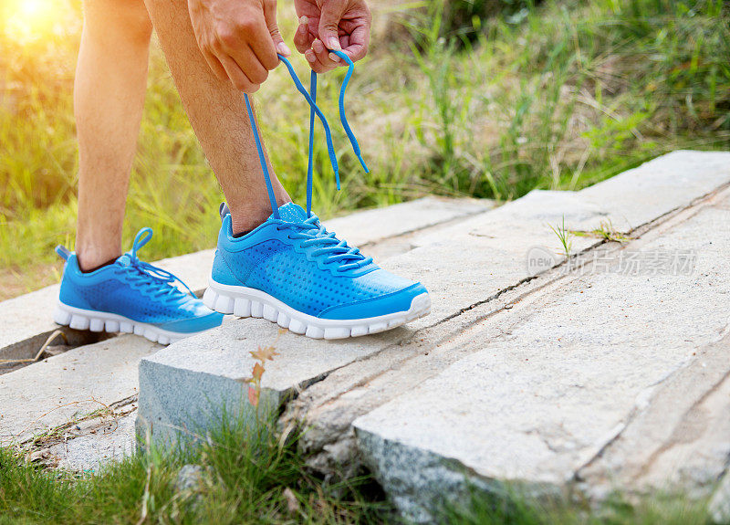 Man tying shoes preparing for a jog